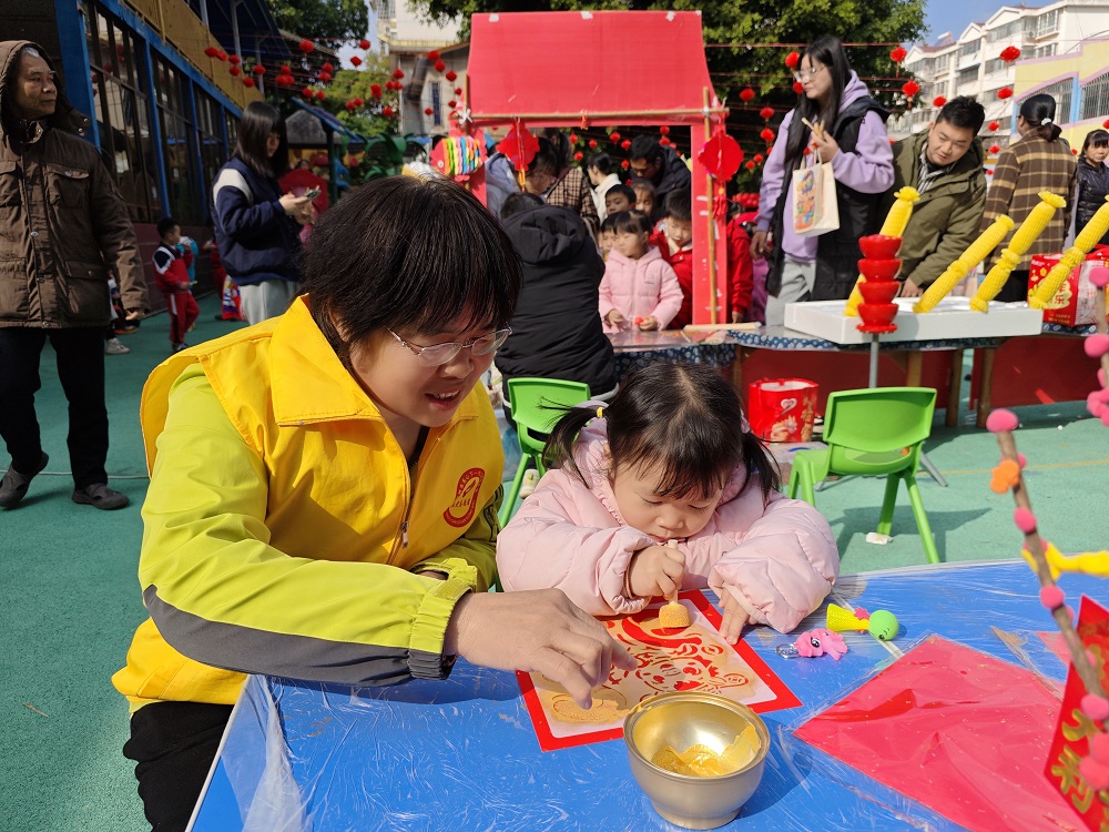 【非遺廟會迎新春  傳統(tǒng)文化潤童心】“五老”志愿者協(xié)助小朋友拓印吉祥圖案1.jpg